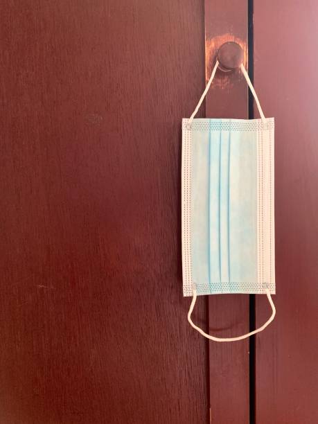 istock One Face Mask Hanging on Cupboard Doorknob 1285679211
