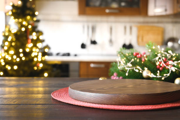 istock Wooden tabletop with gold gift Christmas decoration and blurred modern kitchen as background. 1285682396
