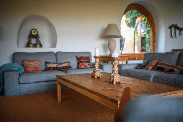 Living room interior with sofa and colorful pillows and glass table in front
