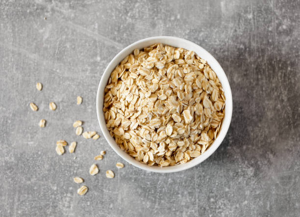 istock Bowl of oat flakes on grey kitchen table, top view 1285684631