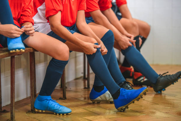 練習前に靴下と靴を履く少年サッカー選手 - スパイクシューズ ストックフォトと画像