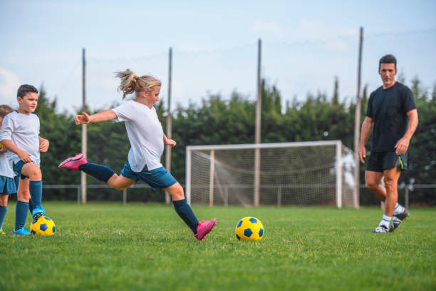 istock Athletic 7 Year Old Girl Footballer Practicing Kicks on Field 1285685656