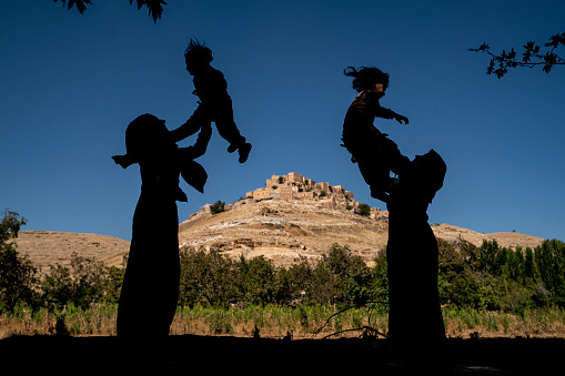dağın zirvesinde bulunan köyde, evler taştan yapılmıştır. Anneler ve çocukları köy manzarasında birlikte keyifli zaman geçiriyor. Küçük Mardin'i andıran Kalecik köyünde