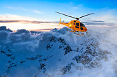 Yellow Helicopter flying over the Rocky Mountains