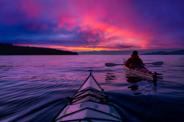 istock Adventure Man on a Sea Kayak is kayaking at Sunset 1285691037