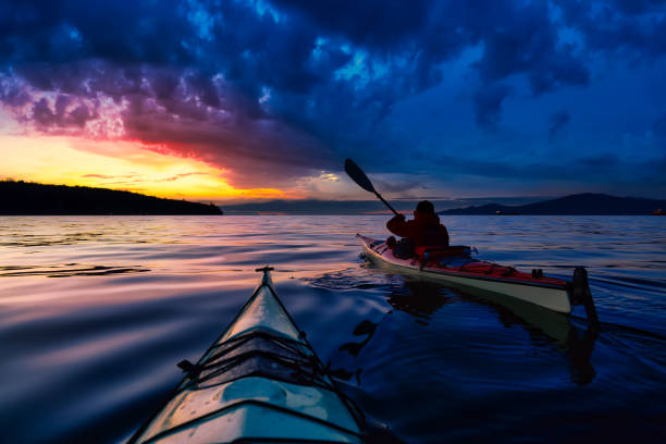 istock Adventure Man on a Sea Kayak is kayaking during Sunset 1285691039