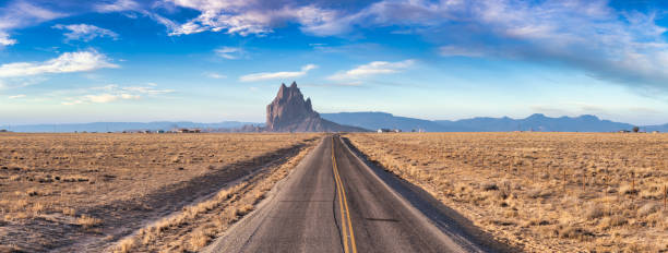 istock Panoramic View of a road in a dry desert with Shiprock 1285691104
