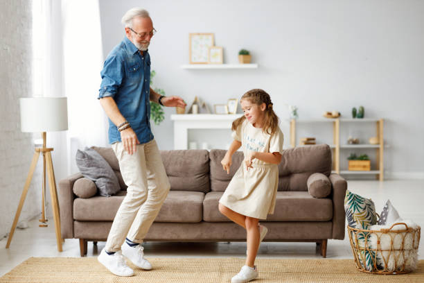 istock Grandfather dancing with granddaughter at home 1285691132