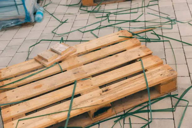 Wooden pallet among the construction debris. Item for transportation and preservation of building materials. Natural wood