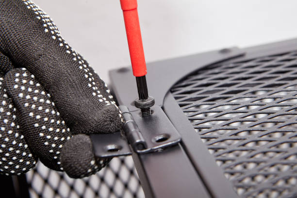 istock Worker is screwing furniture door hinges during assembling TV stand. 1285693203