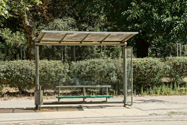 istock one empty transparent glass bus stop with a bench on the asphalt by the road 1285693301