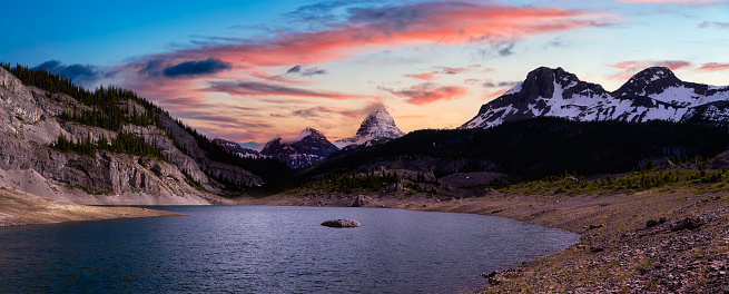 Beautiful Panoramic View of Og Lake in the Iconic Mt Assiniboine Provincial Park near Banff, Alberta, Canada. Canadian Mountain Landscape Background Panorama. Vibrant Colorful Sunset Sky
