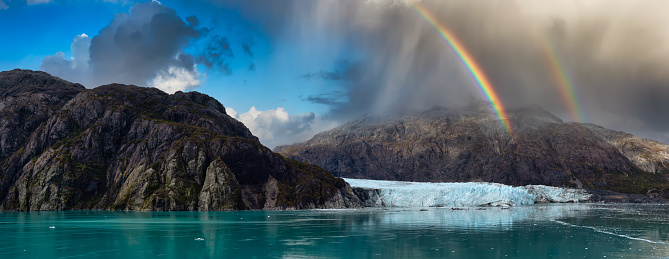 Beautiful Panoramic View of Margerie Glacier in the American Mountain Landscape on the Ocean Coast. Dramatic Sky with Rainbow Art Render. Glacier Bay National Park and Preserve, Alaska, USA.