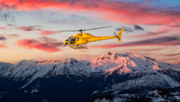 ロッキー山脈の上空を飛行する黄色いヘリコプター。 - action adventure aerospace industry air vehicle ストックフォトと画像