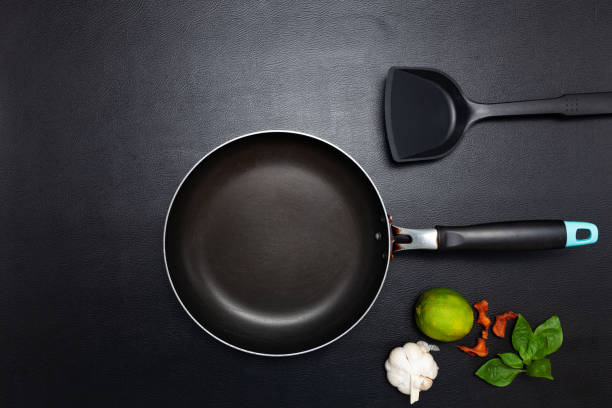 istock Cooking background Top view frying pan and pot on black leather table background. 1285695167