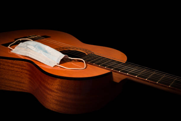 istock Face Mask on an Acoustic Guitar Close Up on a Black Background. 1285695428
