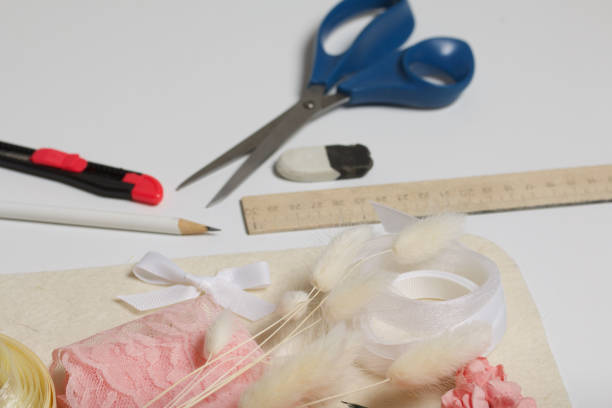 istock Needlework accessories. Dried flowers and ribbons for crafts. Tools for creativity. On a white tabletop. 1285699254