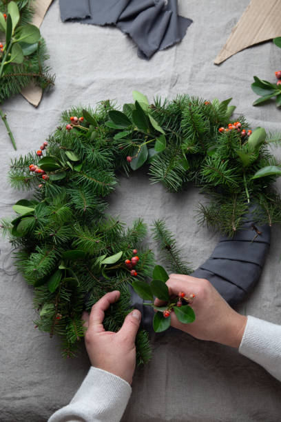 istock Man making Christmas wreath. New year holiday decoration 1285701118