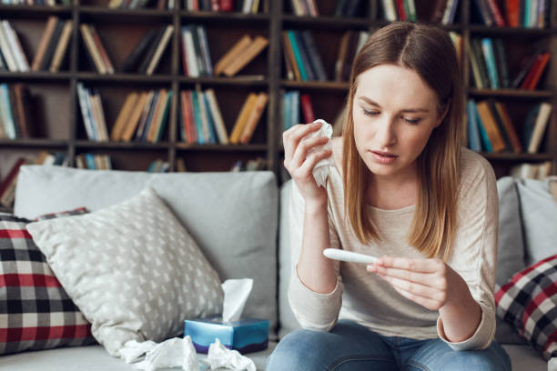 istock Woman alone sitting at library illness concept checking temperature 1285702981