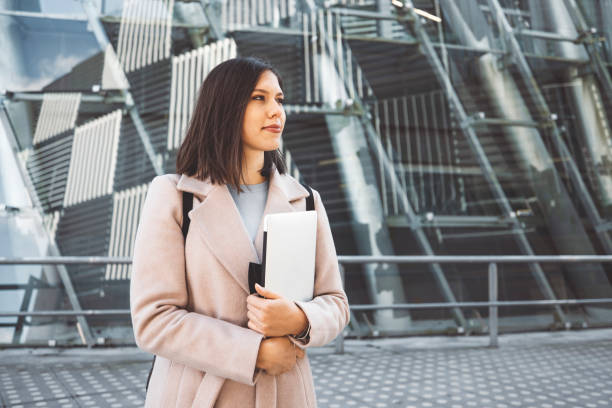 istock College student outside in between classes holding her laptop 1285703755