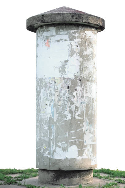 istock Grunge grey vintage concrete advertising pillar, blank empty copy space background, isolated vertical closeup, removed torn glued ads, green grass 1285706620