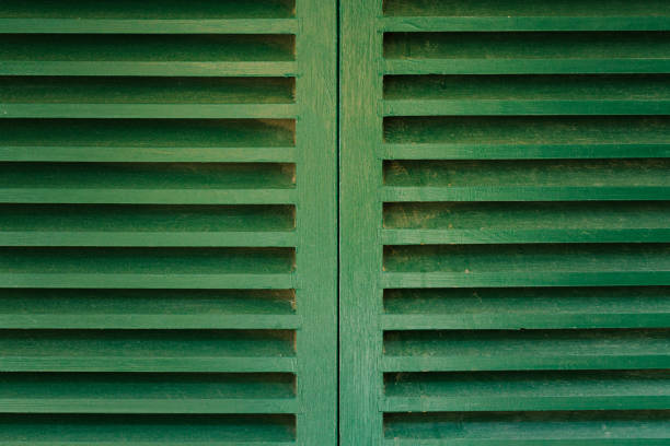 Closed green wooden window shutters.