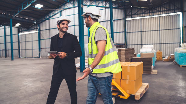 工場労働者は、倉庫内の押し台に箱のパッケージを提供します。 - warehouse manager place of work portrait ストックフォトと画像