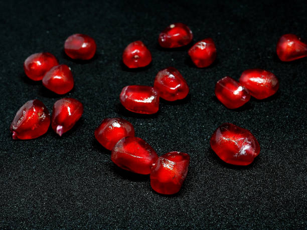 istock red grains of ripe pomegranate on a black background, macro 1285724375