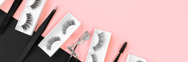 istock Various tools for eye lash extensions on a trendy pastel pink and black background. Banner. Concept. Eyelash curler, tweezers. Makeup accessories. Cosmetics. Fake eyelashes. Place for text. Top view. 1285725970