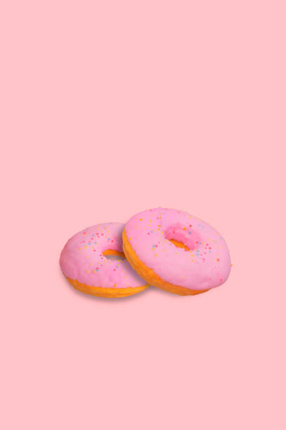 istock Sprinkled Pink Donut isolated on pink background 1285726658