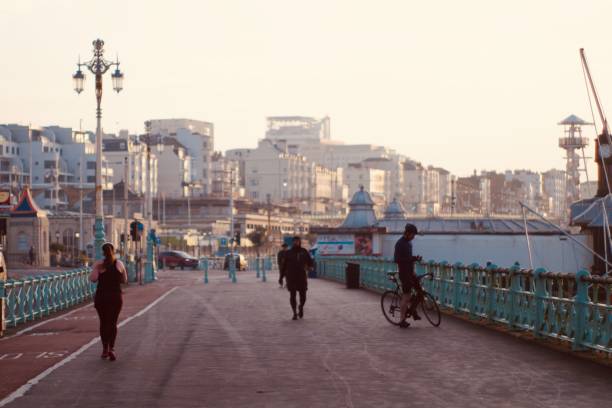 People exercising at Brighton beach promenade at dawn during the second coronavirus lockdown in the UK. Captured in the early morning of the 7th November 2020. Brighton is a constituent part of the city of Brighton and Hove, a former town situated on the southern coast of England, in the county of East Sussex. It is best known as a seaside resort and is positioned 47 miles south of London