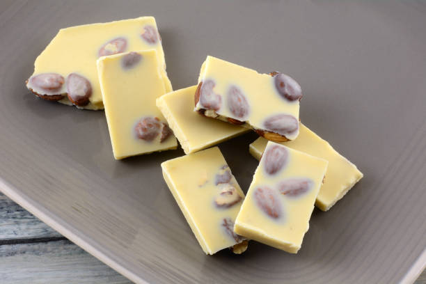 istock Almond white chocolate candy bar pieces with whole almond nuts on brown plate 1285734317