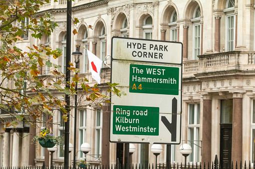 Hyde Park Corner in City of Westminster, London, with road signs towards Hammersmith, Kilburn and Westminster. In the background is the Embassy of Japan.