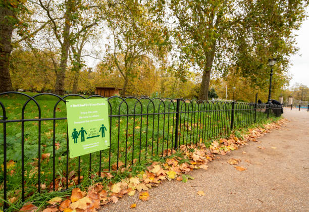 Social Distancing in Hyde Park, London A Covid-19 warning in autumn in Hyde Park, London. The sign has been placed by the Royal Parks. hyde park london photos stock pictures, royalty-free photos & images
