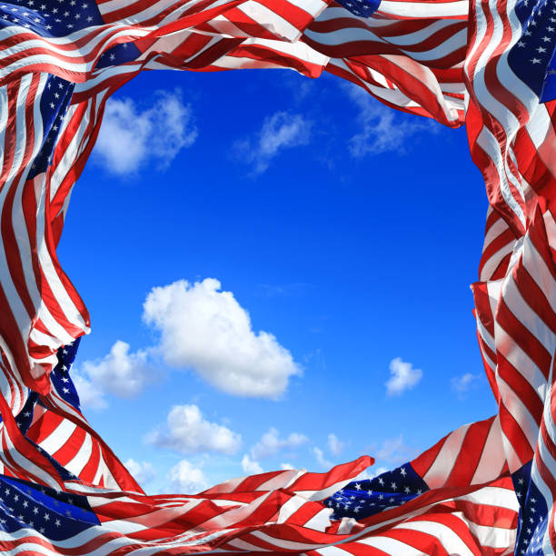 Frame of waving American flags over clear blue sky.