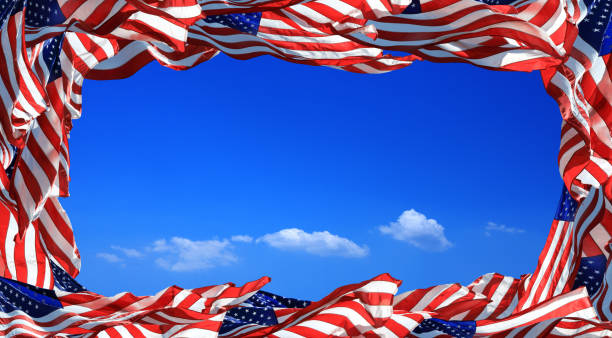 istock Frame of close up waving American flags over clear blue sky. 1285740076