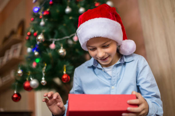 istock Boy opening Christmas present and smiling 1285745426
