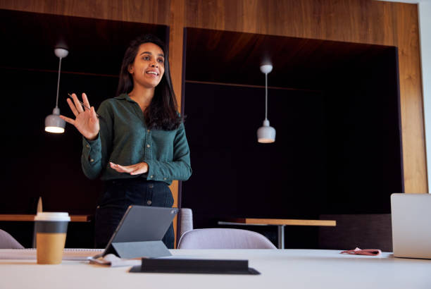 istock Businesswoman With Digital Tablet Giving Presentation In Modern Open Plan Office 1285746141