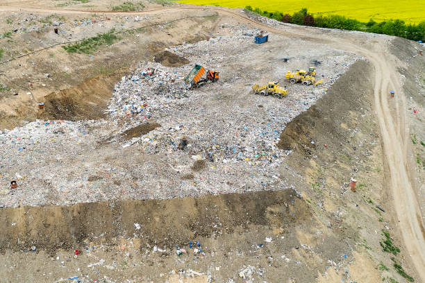 istock Garbage pile in trash dump or landfill. Dump trucks and excavators unloading waste. 1285748540