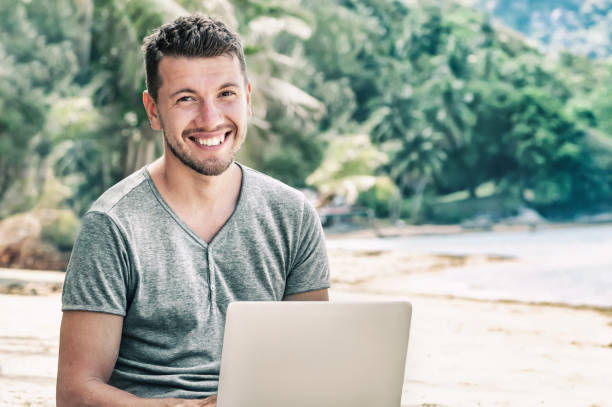 istock Man freelancer with laptop on the beach lifestyle 1285749893