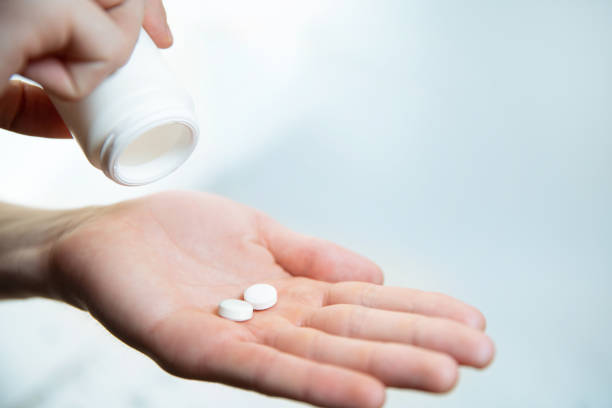 istock close up. two tablets in the palm of a person's hand 1285751019