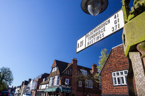 Road Sign in Sevenoaks High Street, England, with stores and restaurants visible in the background