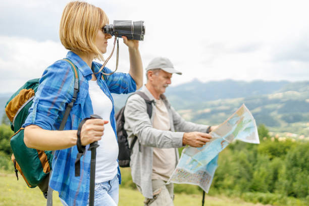 istock Young woman looking through binoculars when going for a hike with father 1285752306