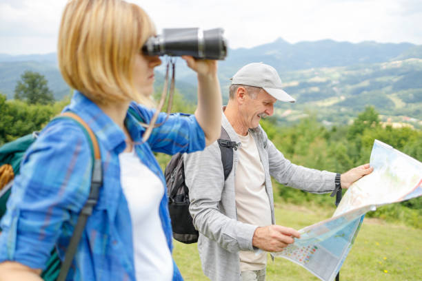 istock Father consulting a map and daughter looking through binoculars during a hike 1285752312