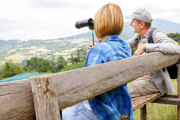Father and daughter taking a rest during a hike and observing nature through the binoculars