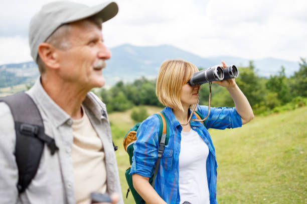istock Elderly man hiking with his daughter, woman looking through binoculars 1285752327