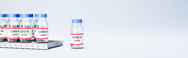 istock Covid 19 Vaccine Bottles on Conveyor Belt on Blue with Copy Space 1285755352