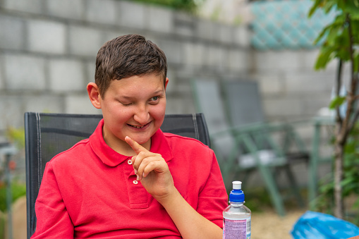 Disabled partially blind boy at back yard BBQ