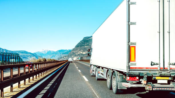 semi vrachtwagen die op lege weglijn te snel is - het logistieke concept van het vervoer met semitruckcontainer het drijven op speedway - nadruk op centraal deel van achtergrond - brennerpas stockfoto's en -beelden