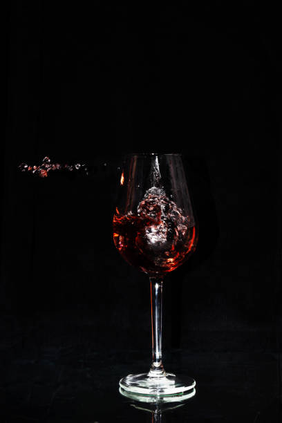 Close up of a crystal glass into which wine is poured stock photo